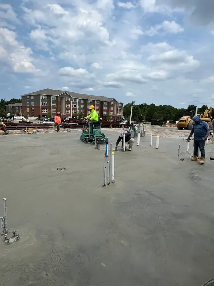 A group of construction workers are working on a concrete floor.