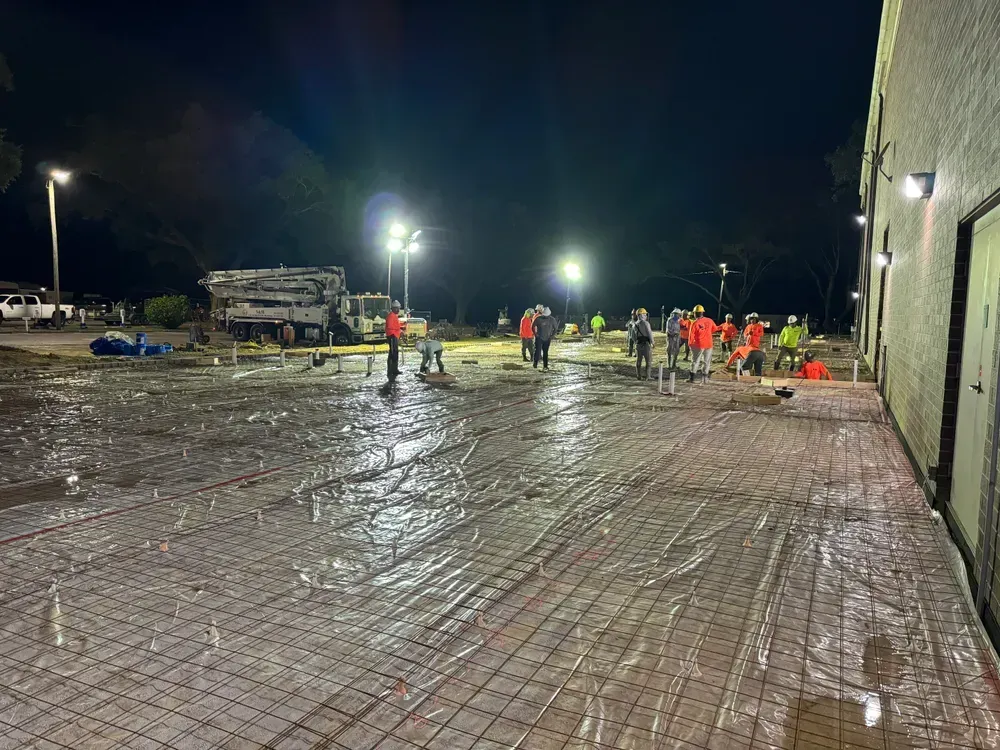 A group of people are working on a construction site at night.