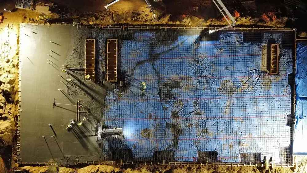 An aerial view of a building under construction at night.