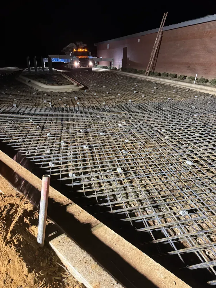 A construction site at night with a truck parked in the background.