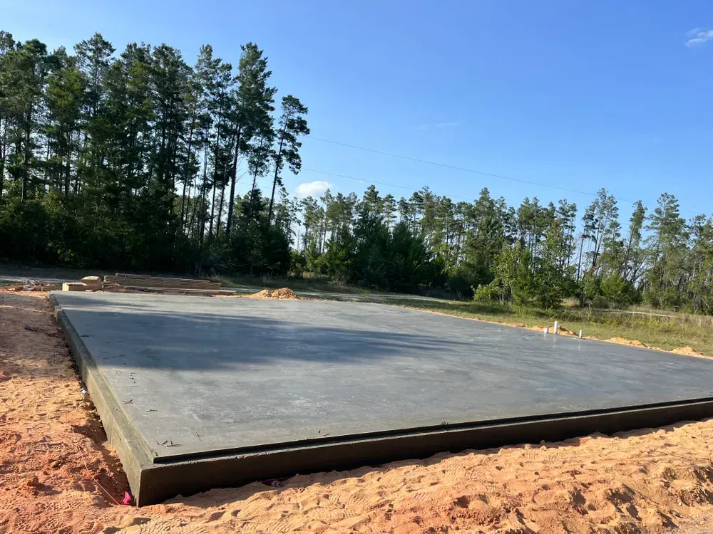 A large concrete slab is sitting in the middle of a dirt field.