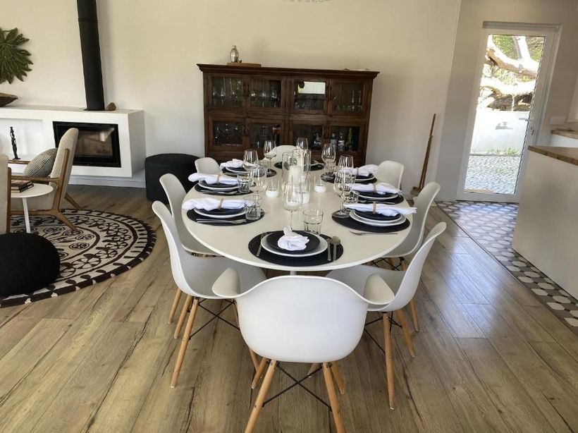A dining room with a round table and white chairs