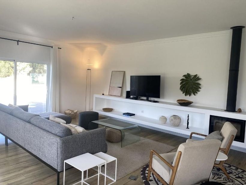 A living room with sofa, chair, table and television.