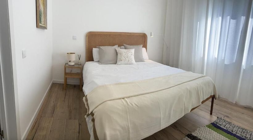 A bedroom with bed, bedside table and window.