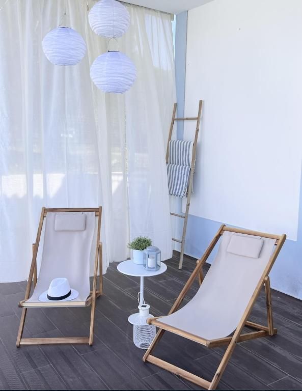 Two chairs and a table in a room with white curtains