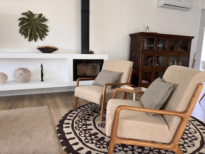 A living room with two chairs and fireplace