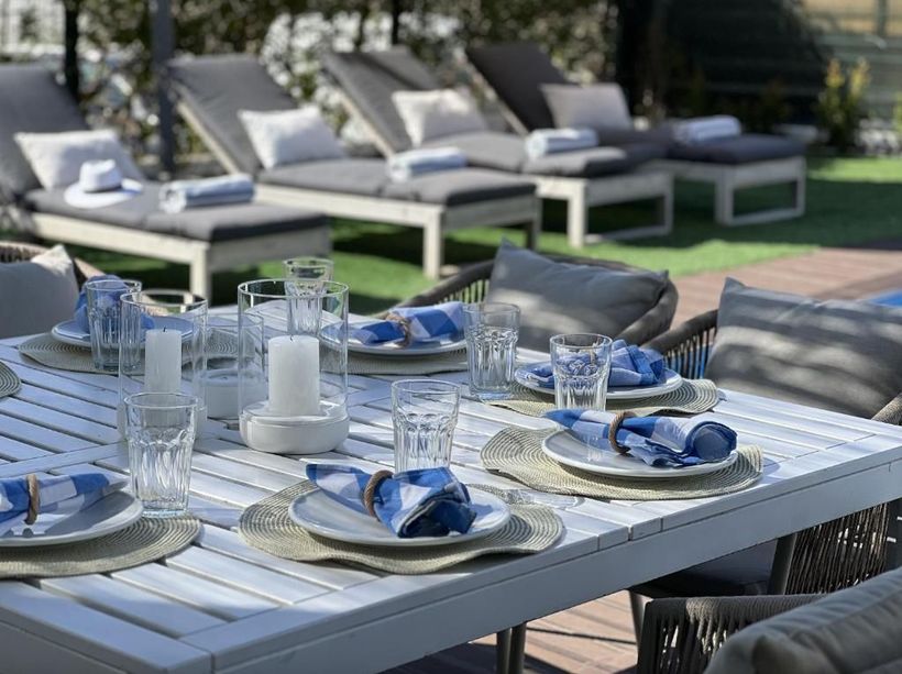 A table with plates, glasses, candles and napkins.