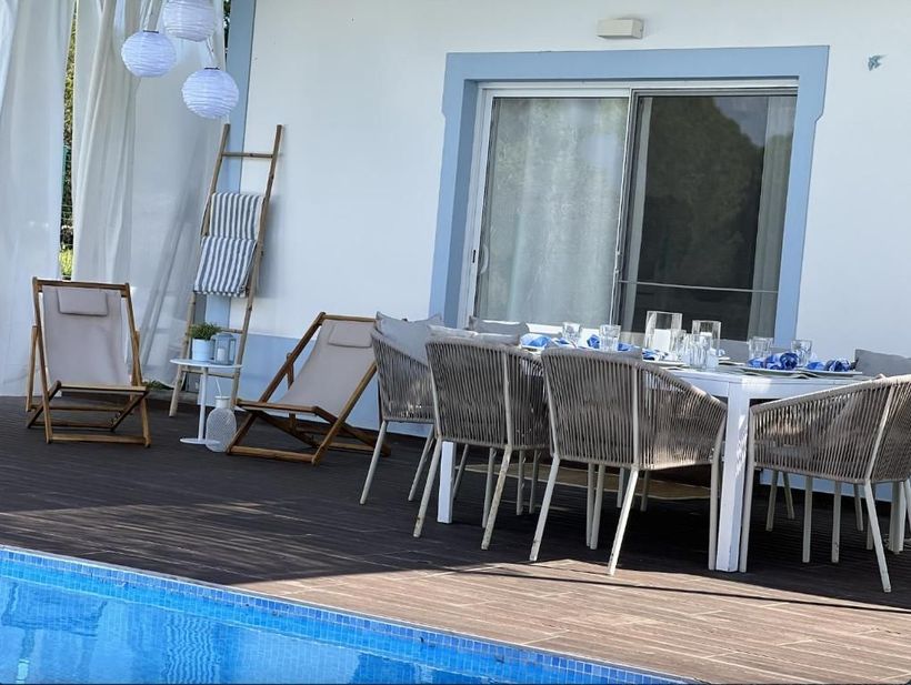A patio with tables and chairs next to a pool