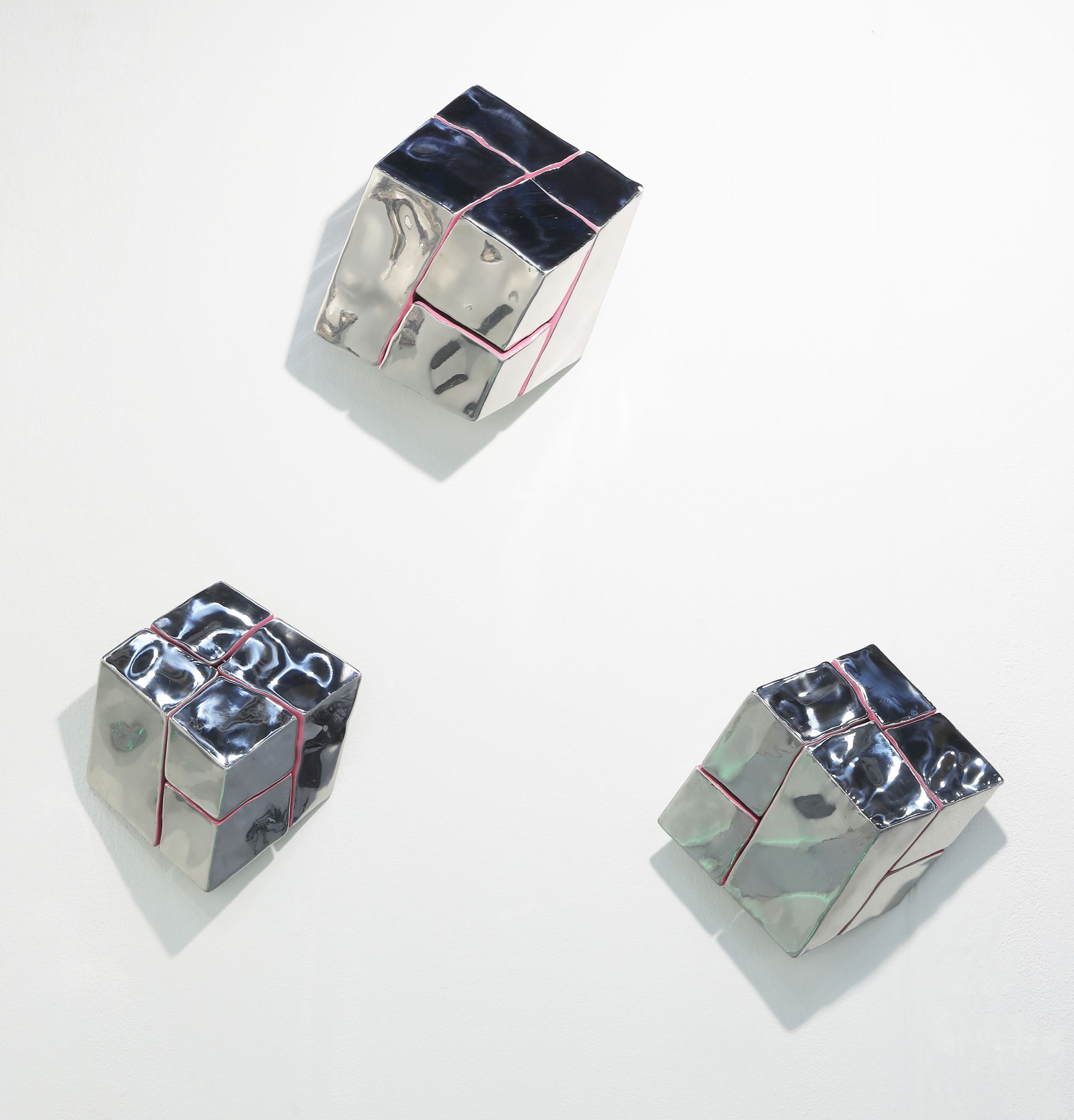 Three cubes are stacked on top of each other on a white surface