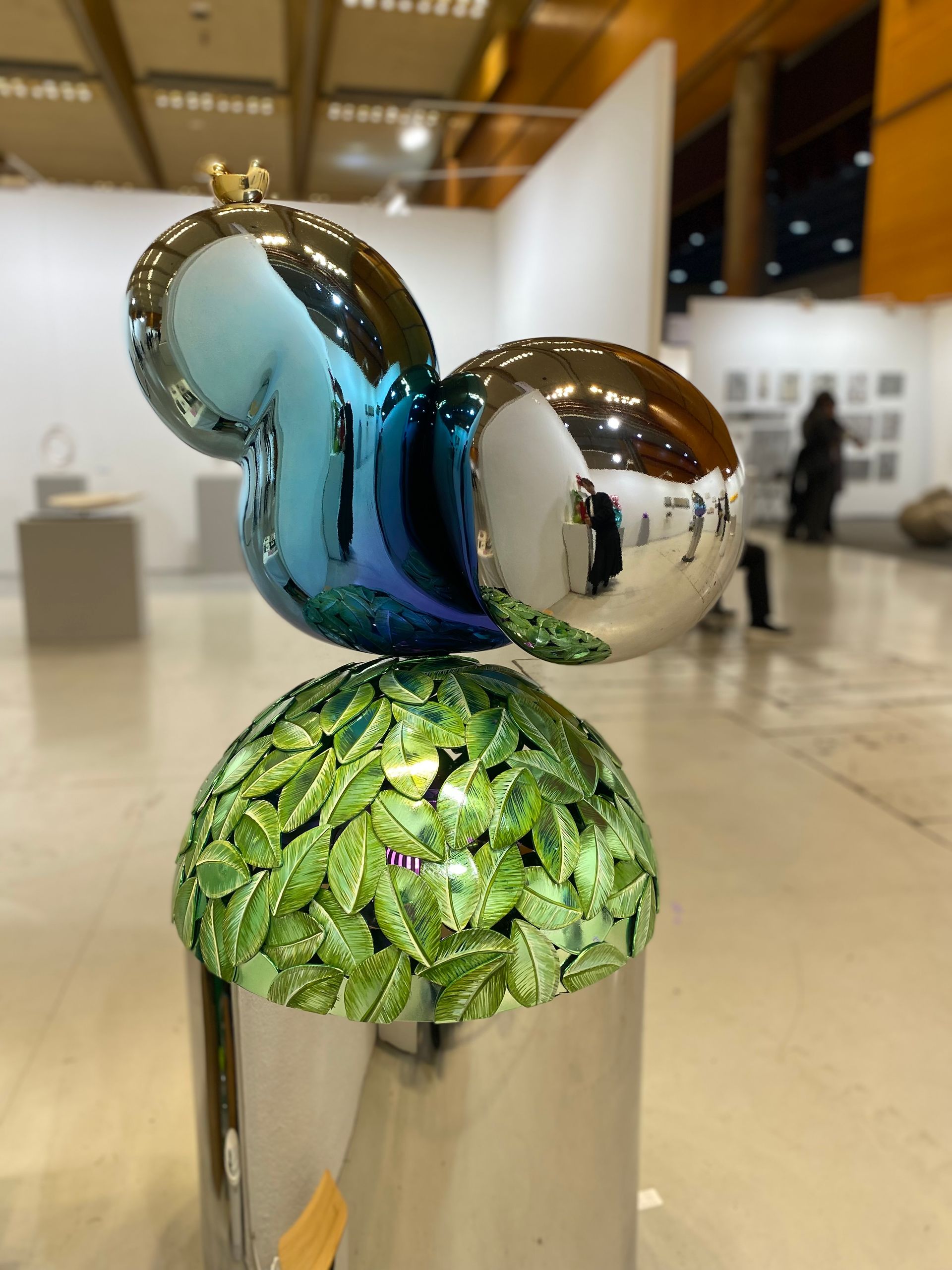 A sculpture of a squirrel with leaves on top of it