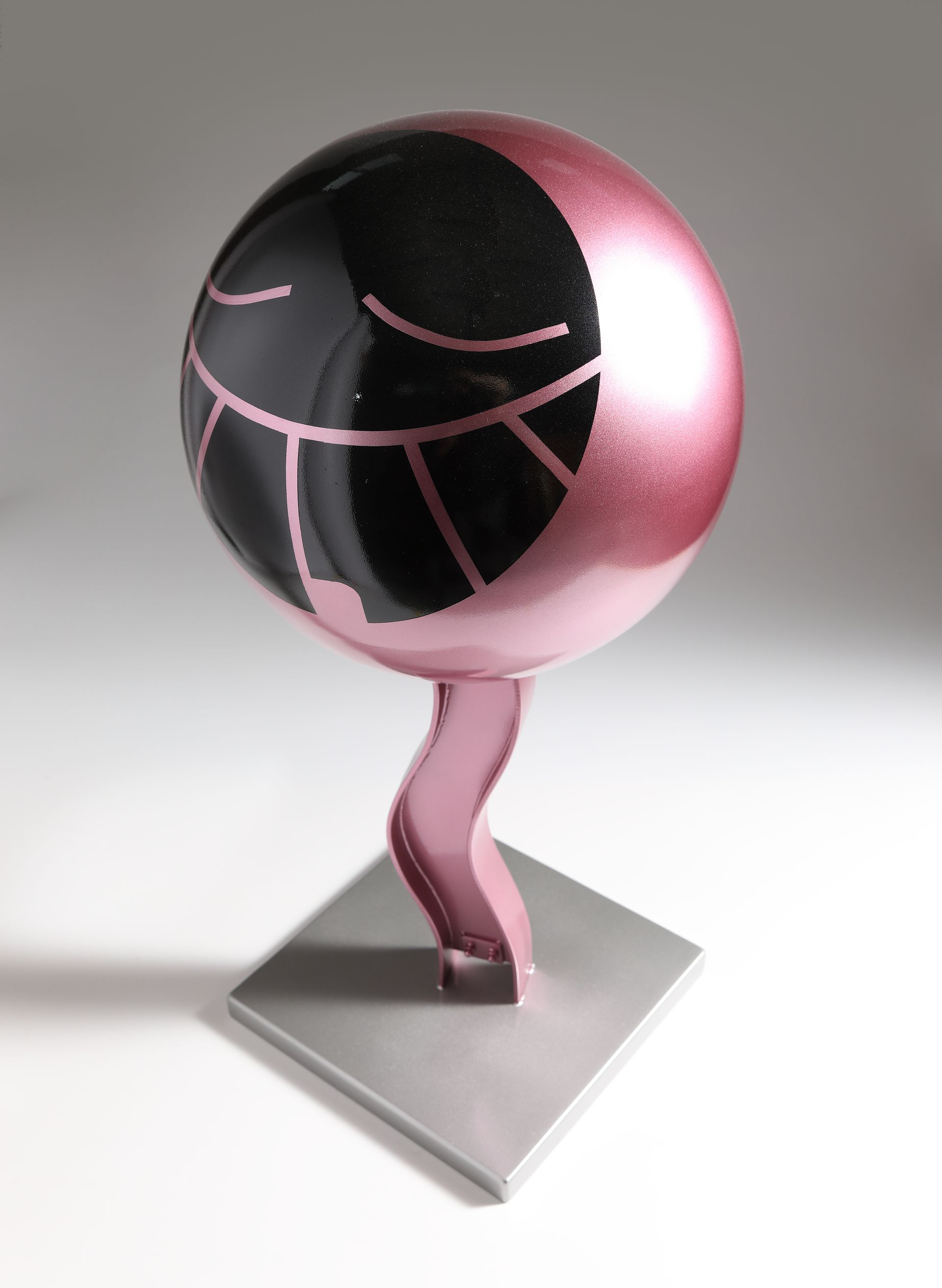 A pink sphere with a black face on it