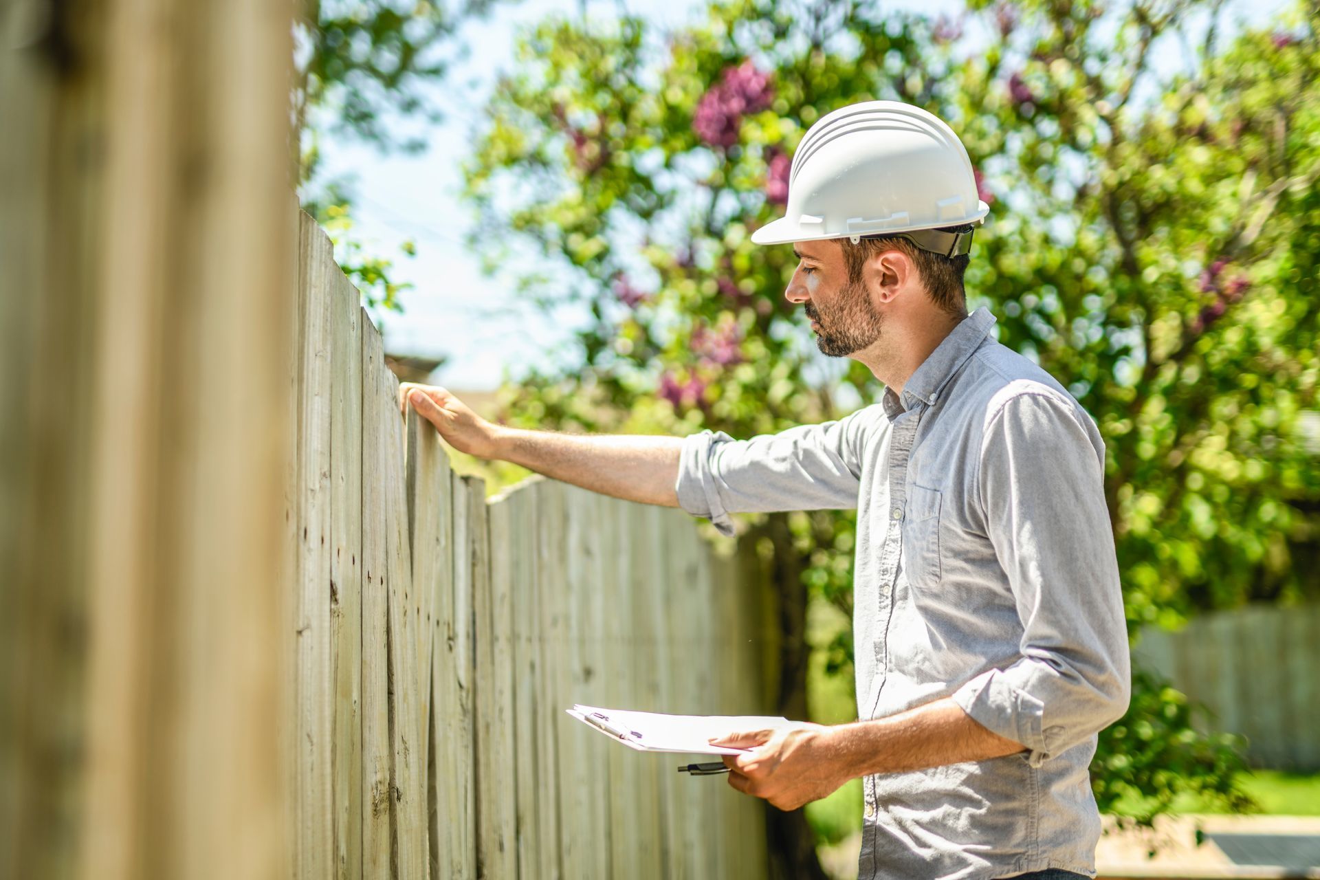 A man is inspecting a fence.