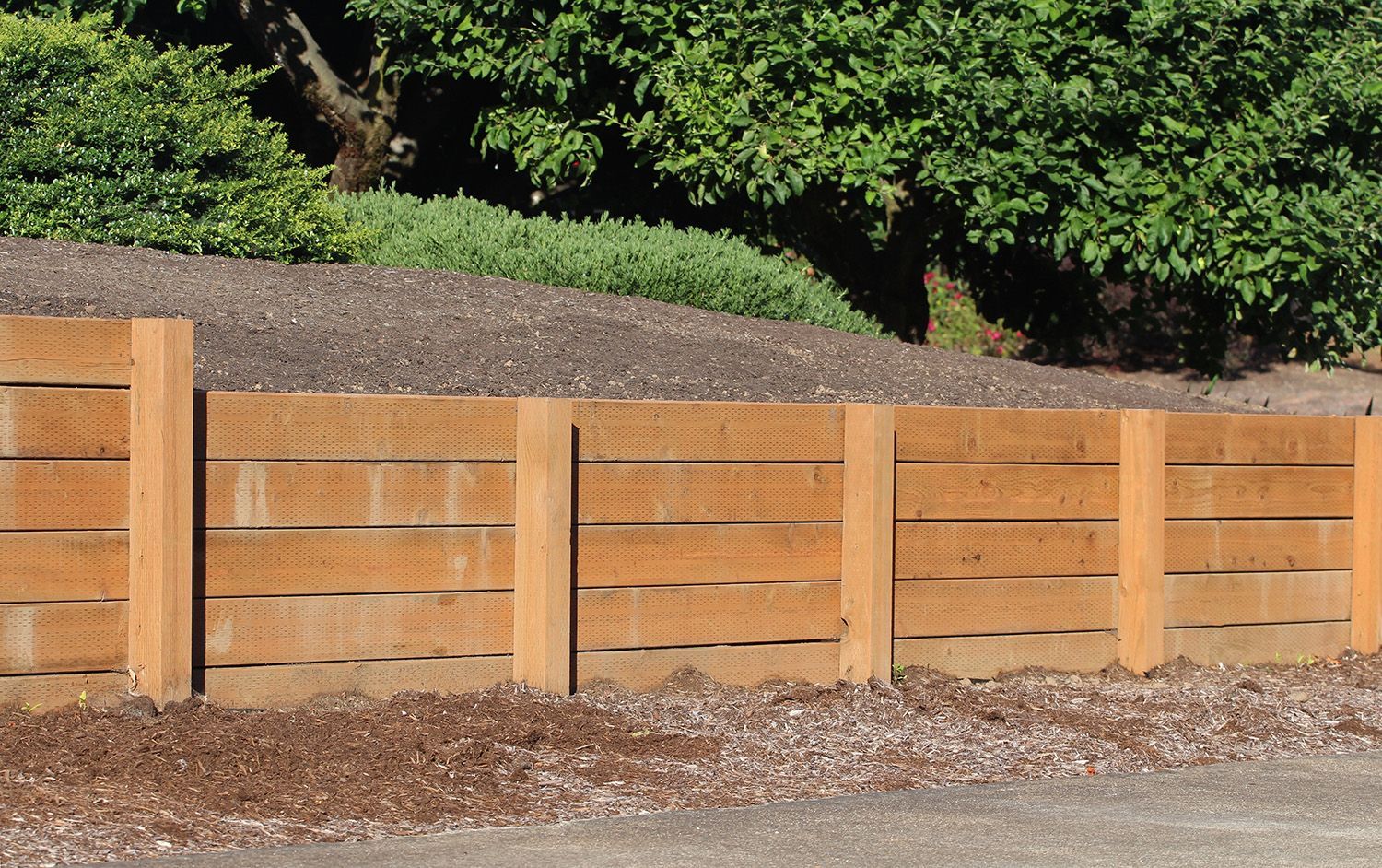 Newly built timber retaining wall holding back soil.