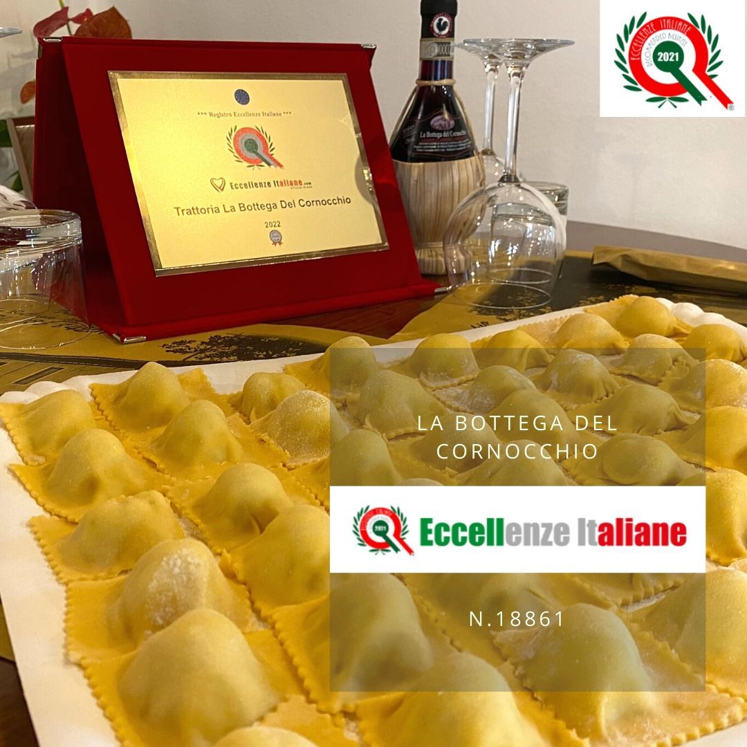 Ravioli di pasta fresca su un vassoio, con una targa rossa e bottiglie di vino sullo sfondo; etichetta Eccellenze Italiane.