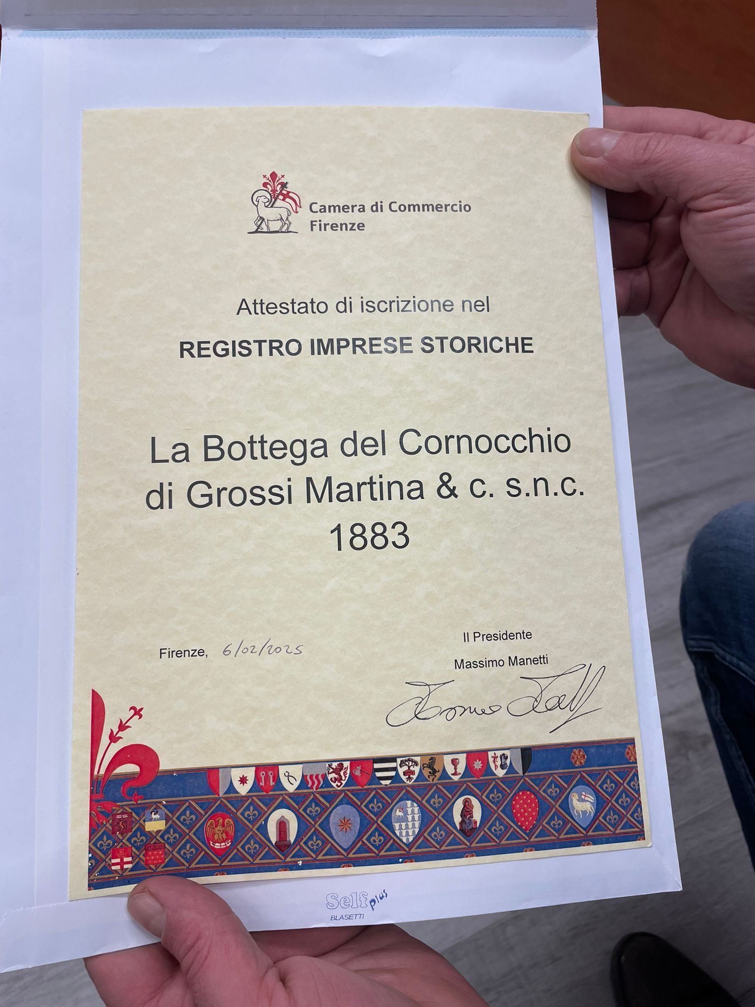 Un documento tenuto in mano, intitolato 