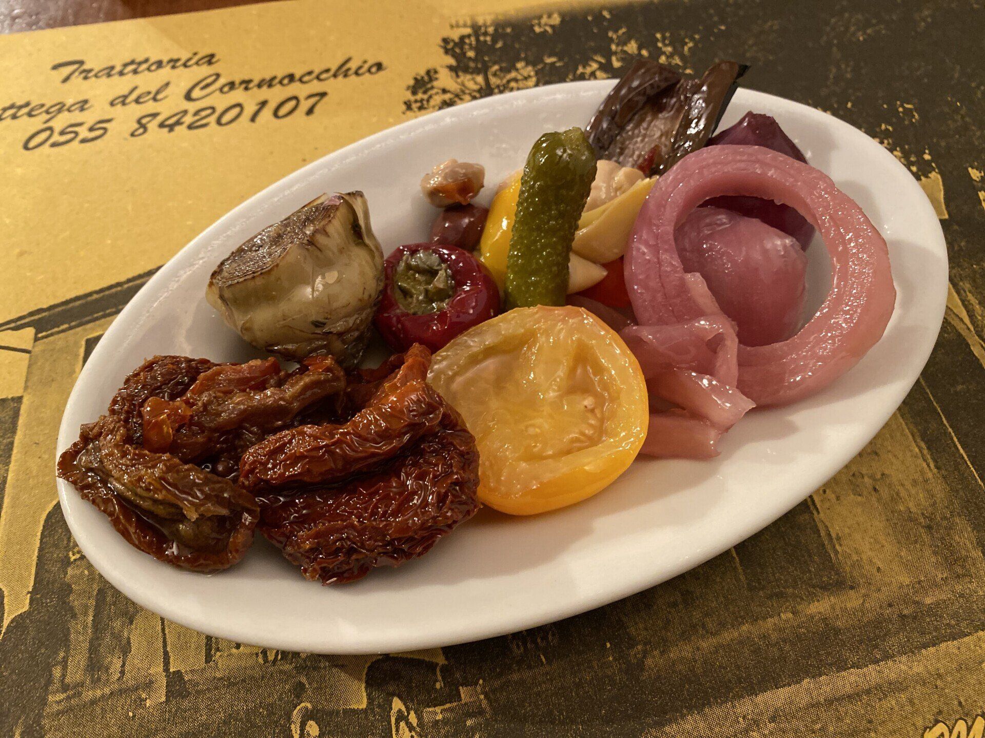 Piatto di antipasto con pomodori secchi, verdure sottaceto e melanzane marinate.