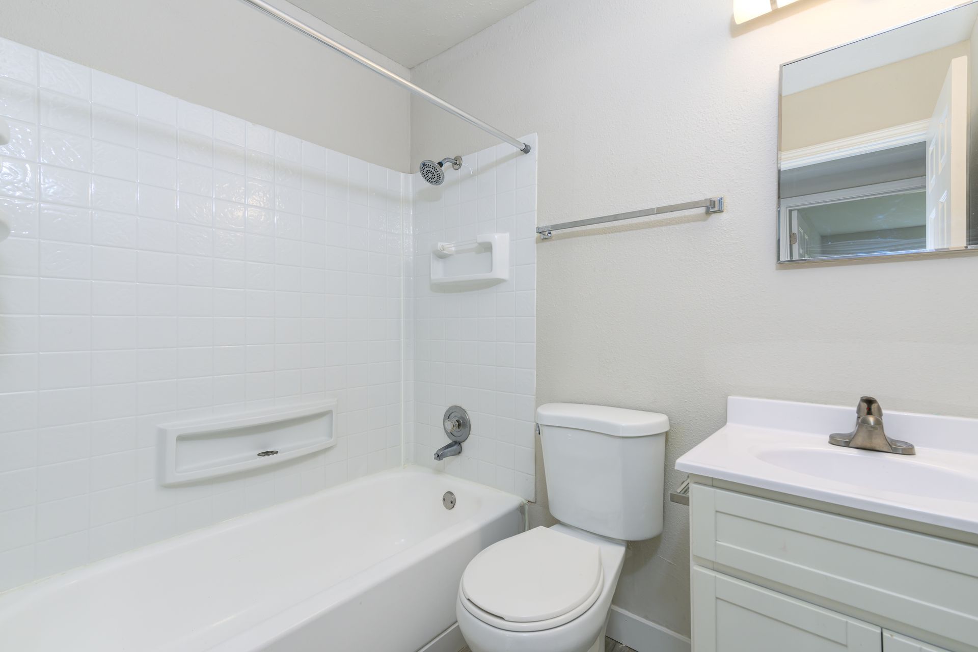 A bathroom with a toilet , sink and bathtub.