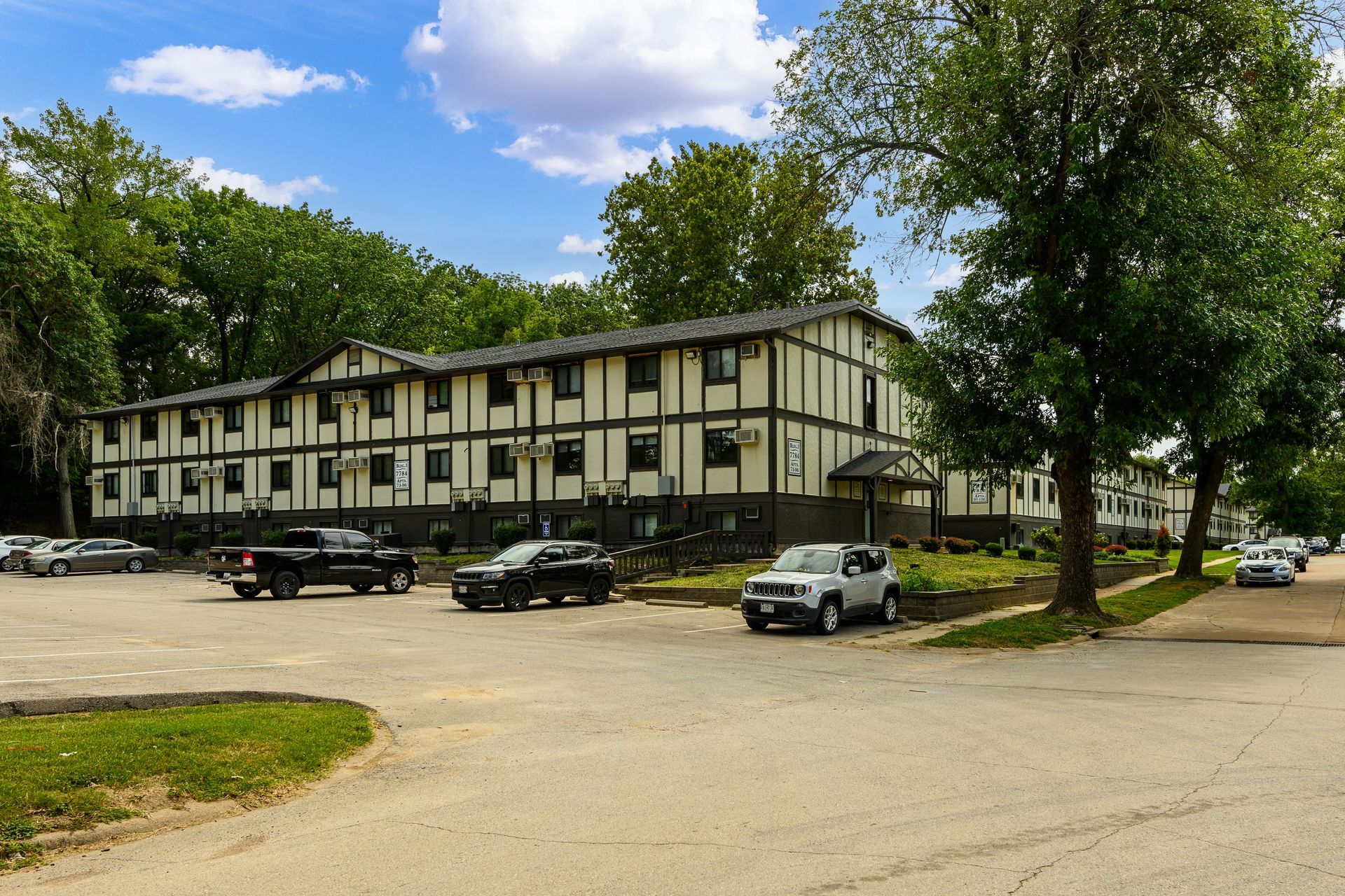 A large building with a lot of cars parked in front of it.