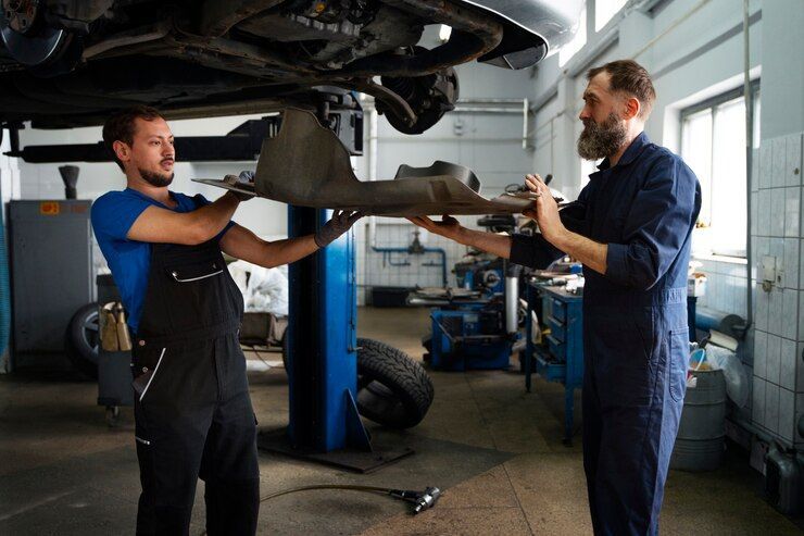 Two Mechanics Are Working On A Car In A Garage — Affordable Mechanic in Albury, NSW