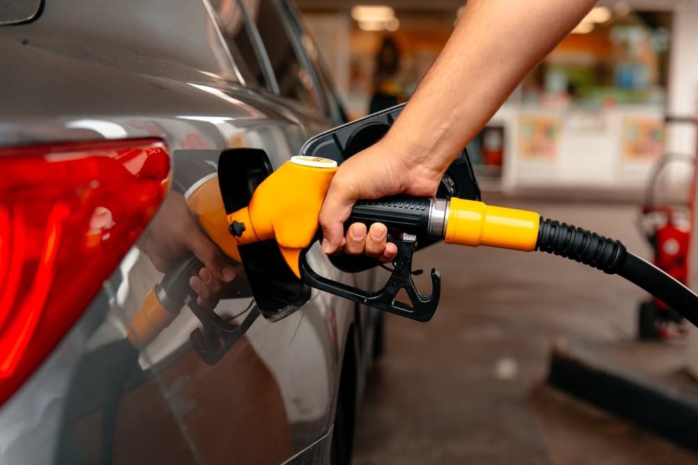 A Person Is Pumping Gas Into A Car At A Gas Station — Vehicle Inspections & Mechanical Services in Albury, NSW