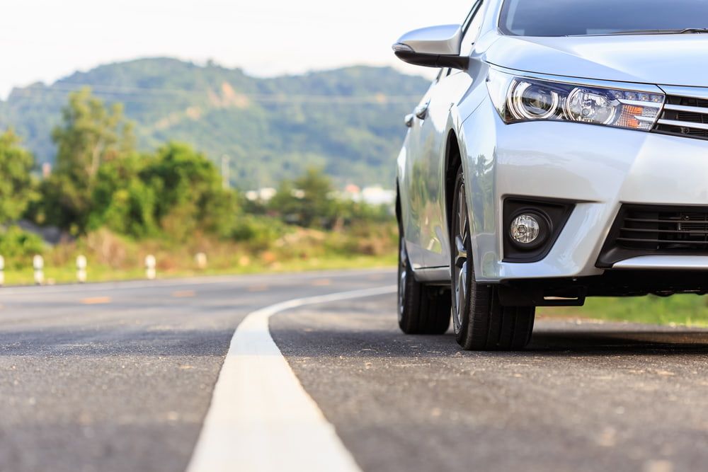 A White Car Is Parked On The Side Of The Road — Comprehensive Logbook Servicing in Albury, NSW