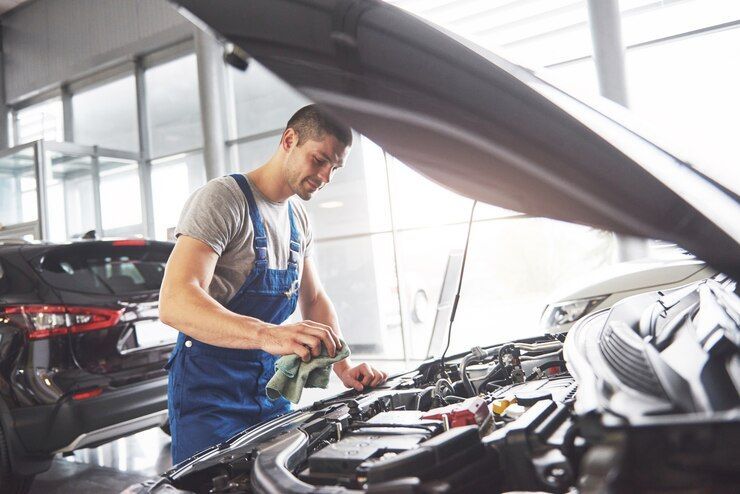 A Man Is Working On The Engine Of A Car In A Garage — Experienced Car Mechanic in Albury, NSW