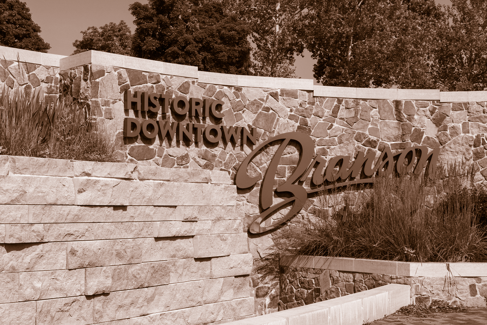 A stone wall with a sign that says historic downtown branson