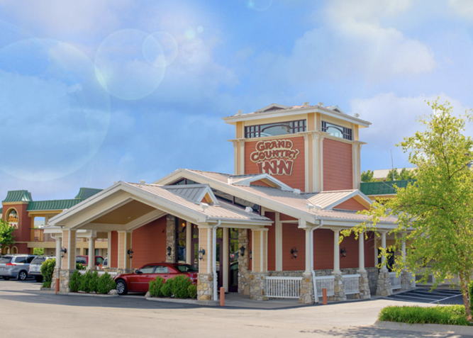 A red car is parked in front of a hotel.