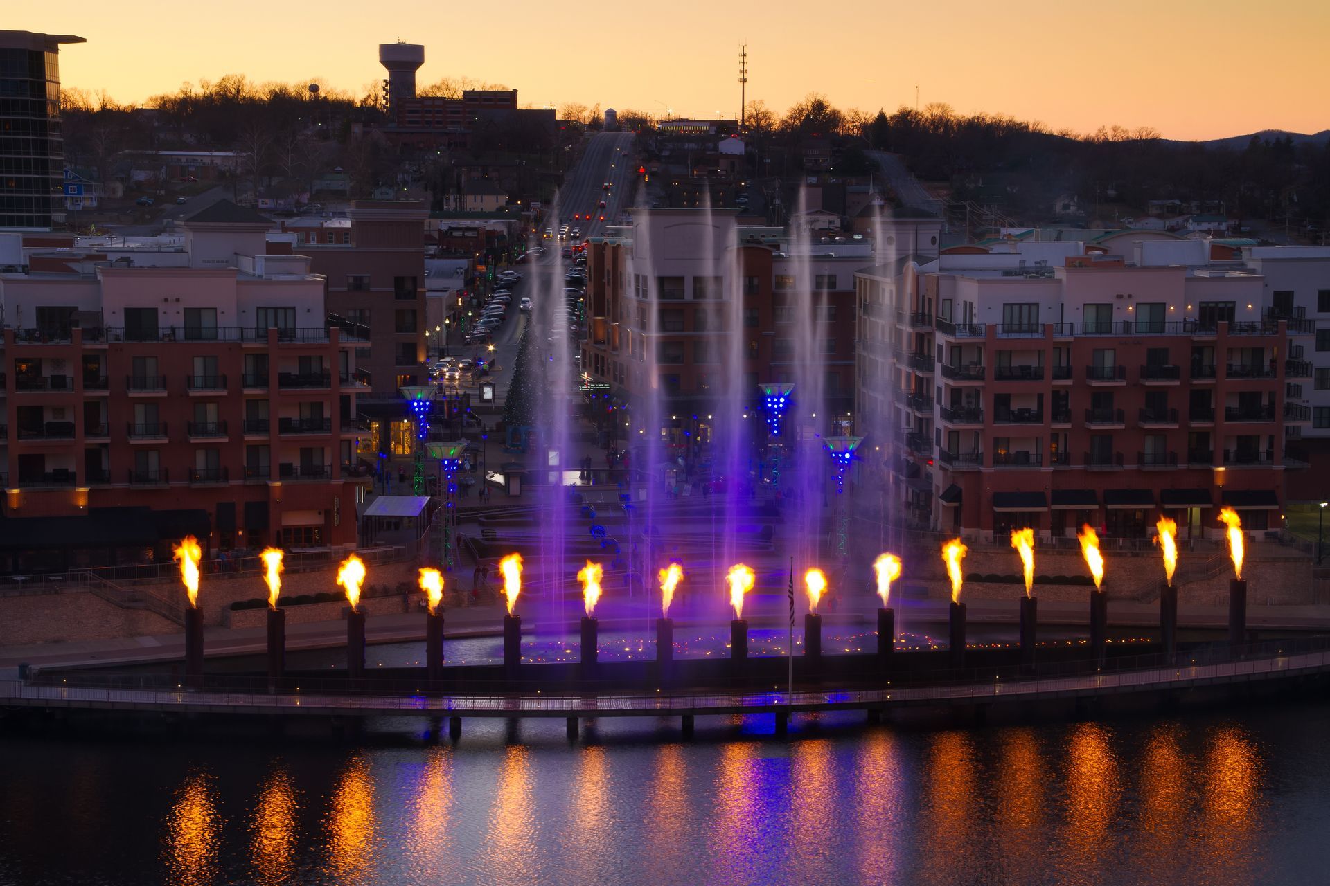 A fountain with flames coming out of it is lit up at night