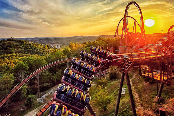 An aerial view of a roller coaster at sunset.