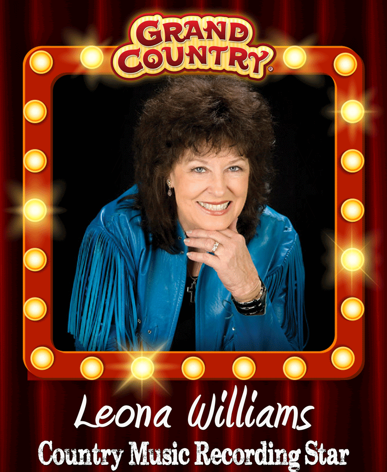 A woman is holding a guitar in front of a red curtain.