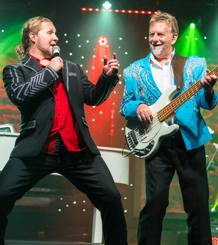 Four performers in western attire promote a country music show in Branson, Missouri, featuring the title Down Home Country.