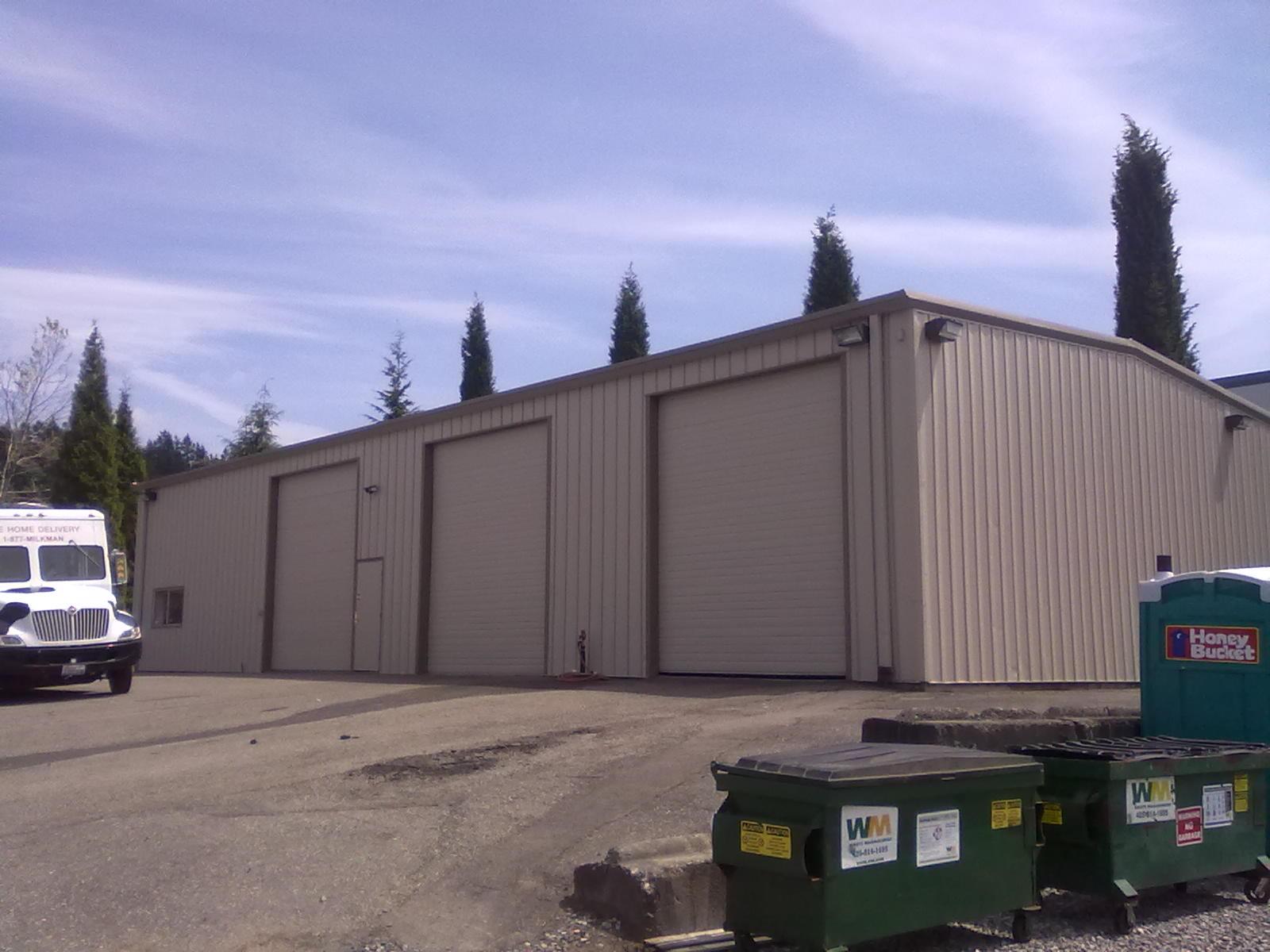 A white truck is parked in front of a large building
