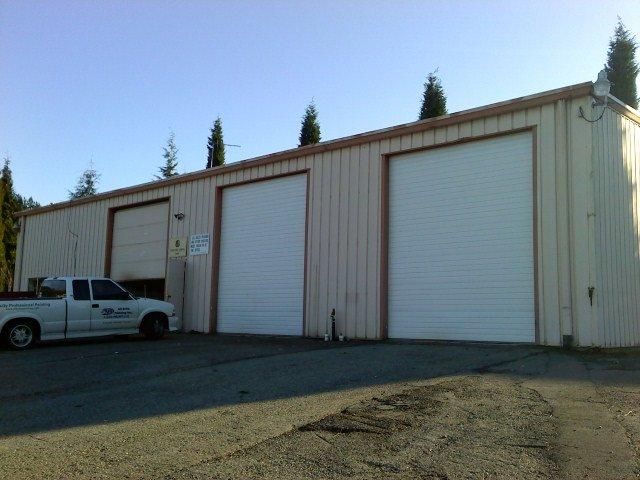A white truck is parked in front of a garage
