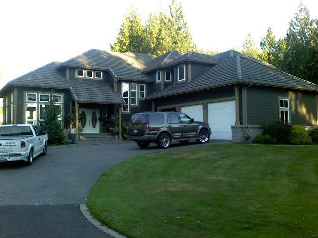 A large house with two cars parked in front of it