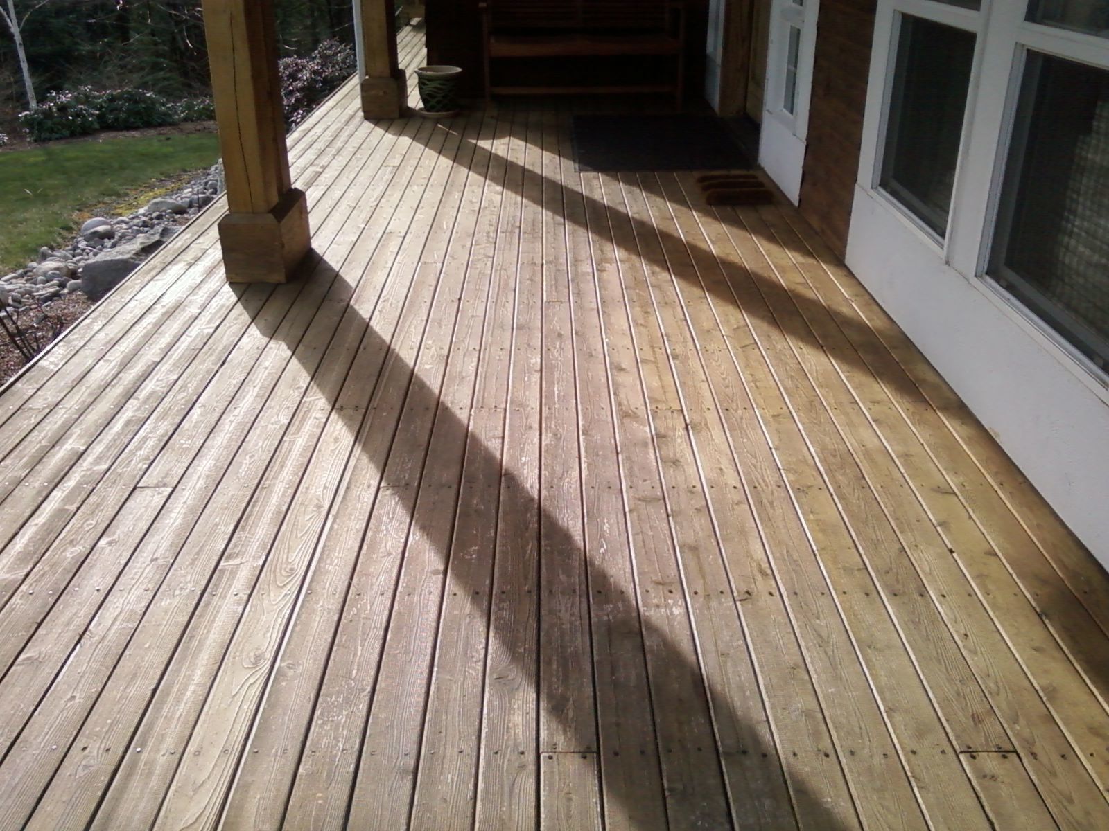 A wooden deck with a shadow of a person on it