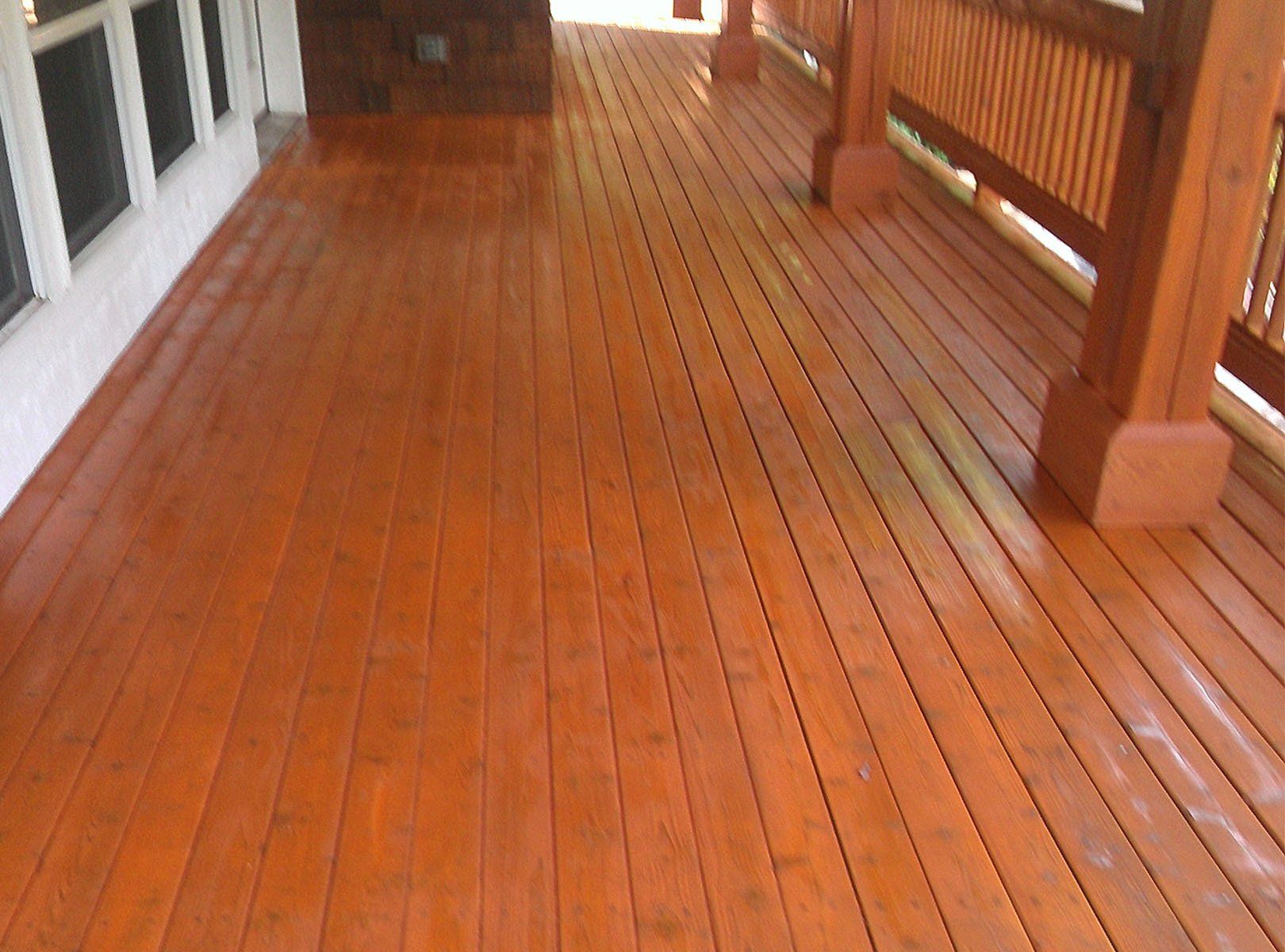 A wooden deck with a railing and a window