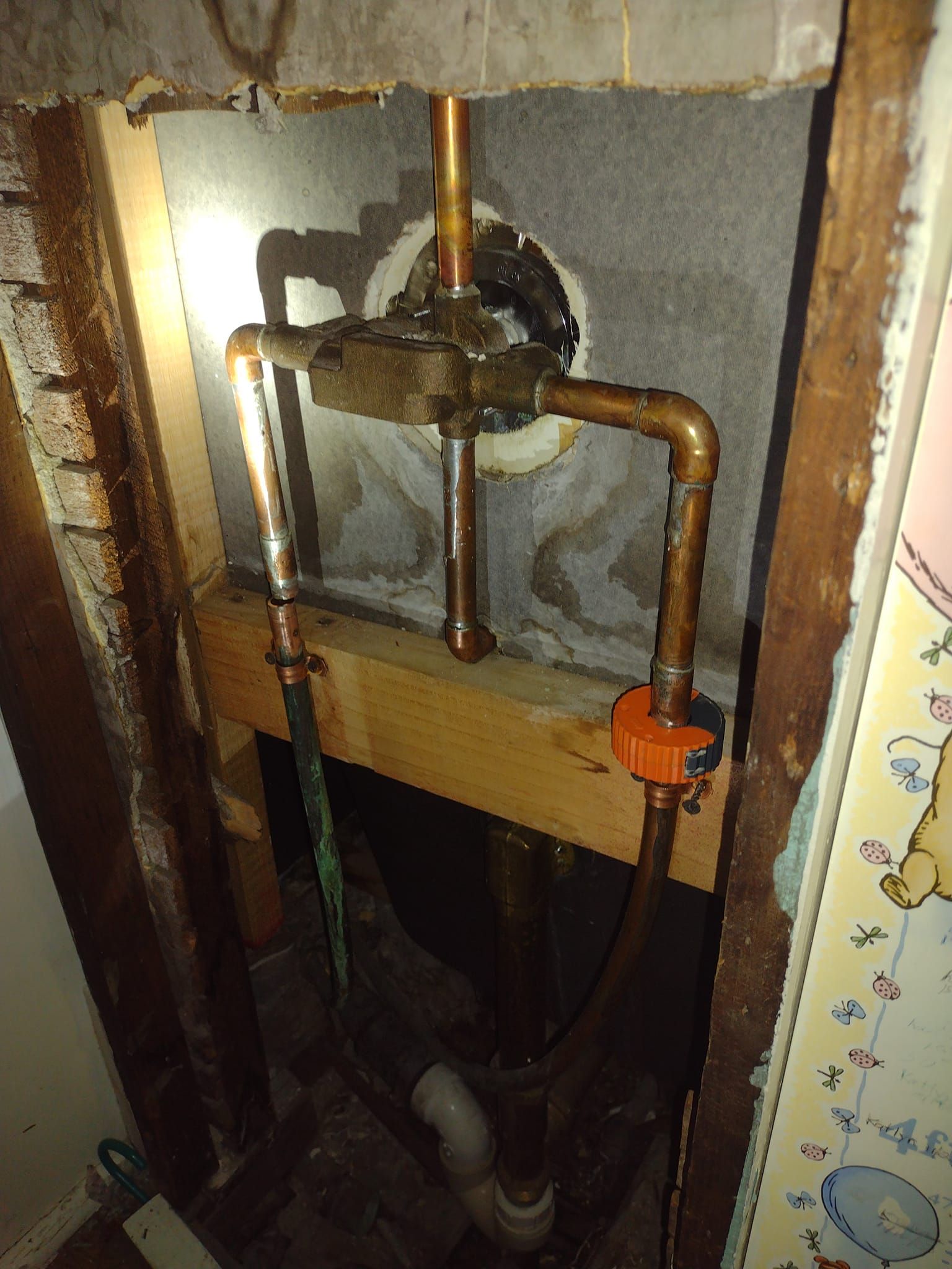 A copper pipe is being installed in a bathroom.