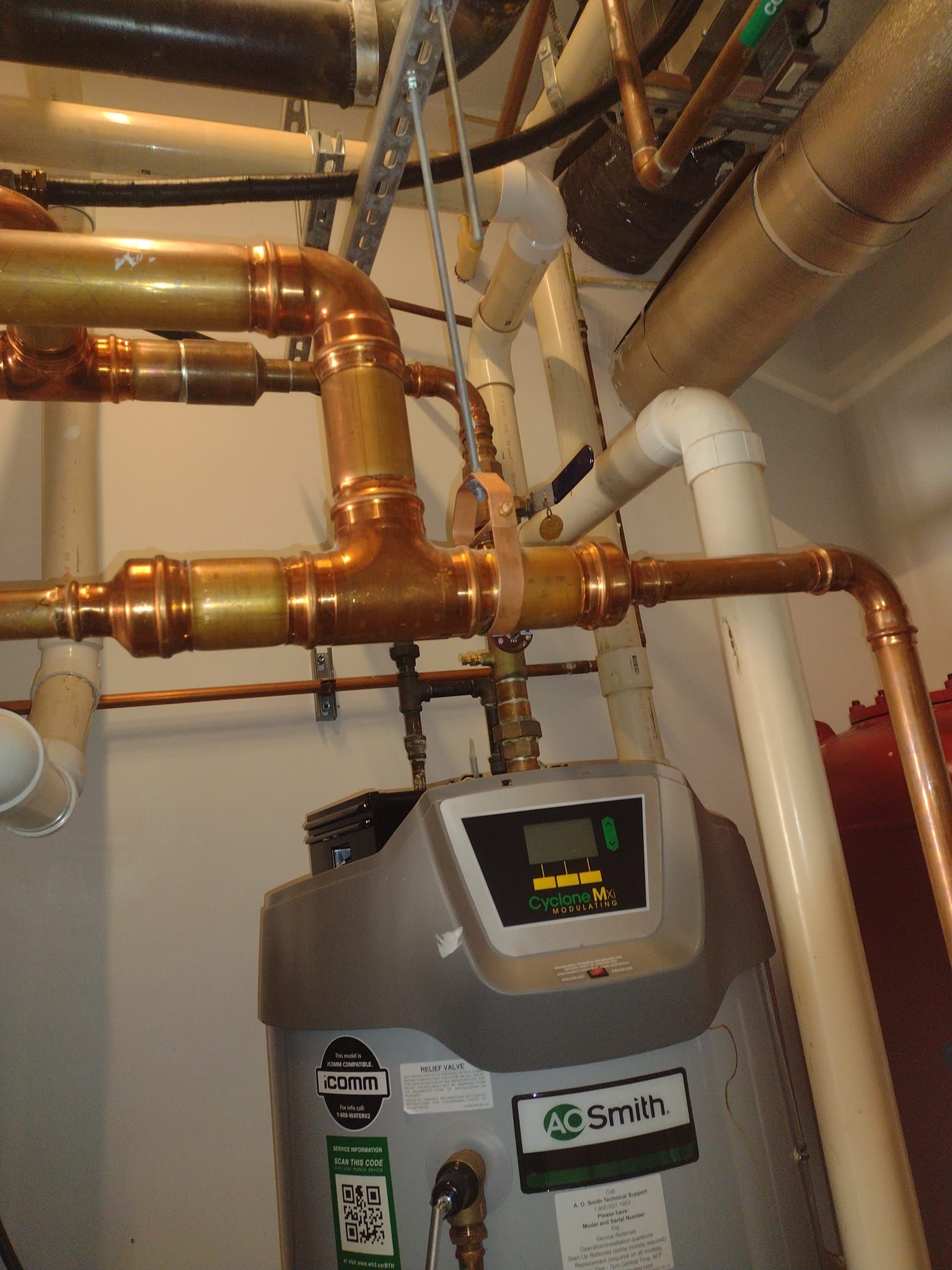 A smith water heater is surrounded by copper pipes