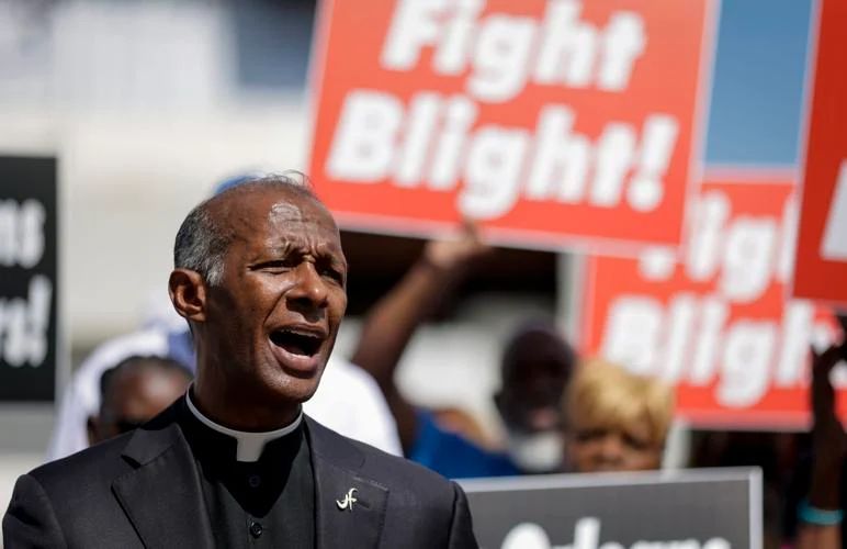 A man holding a sign that says fight blight