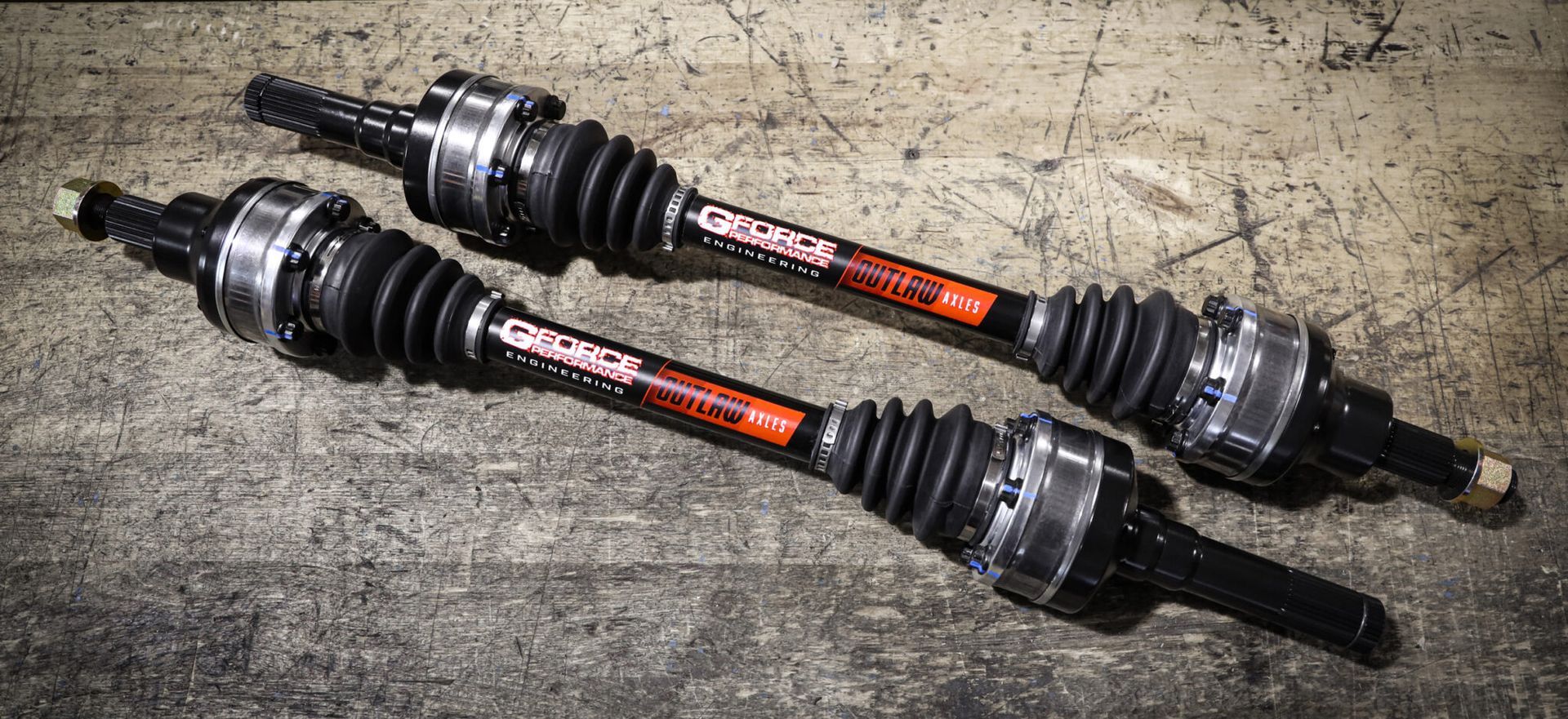 A pair of drive shafts are sitting on top of a concrete surface.