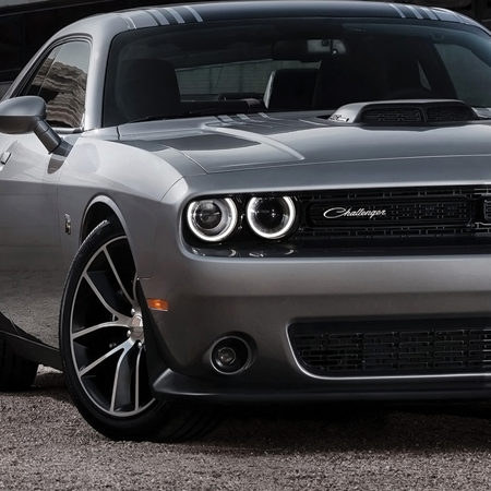 A silver dodge challenger is parked in a parking lot