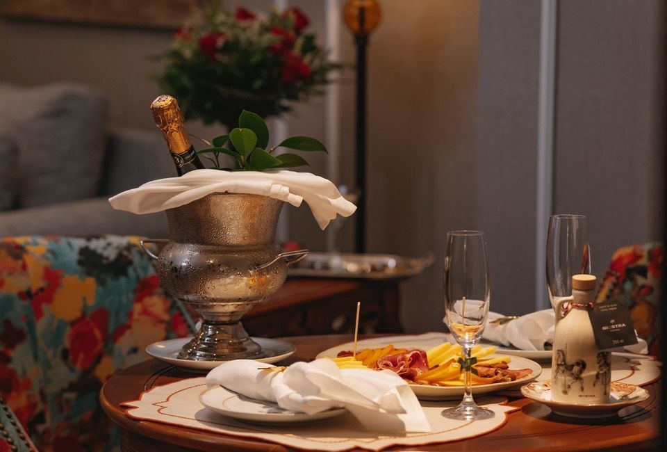 Mesa elegantemente posta com balde de champanhe, prato servido e guardanapos dobrados em uma sala de jantar aconchegante.