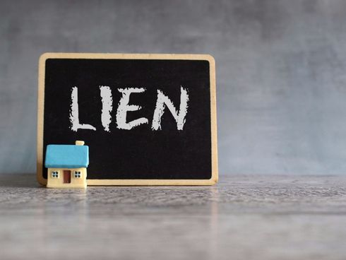 Blackboard with “LIEN” written on it beside a tiny house model