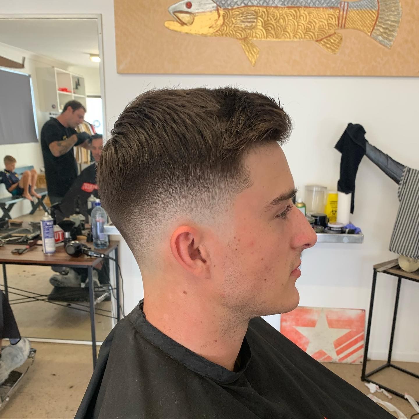 Person Getting a Haircut by a Barber With Clippers and Comb in a Salon — Eagle Tamer Barbershop in Stratford, QLD
