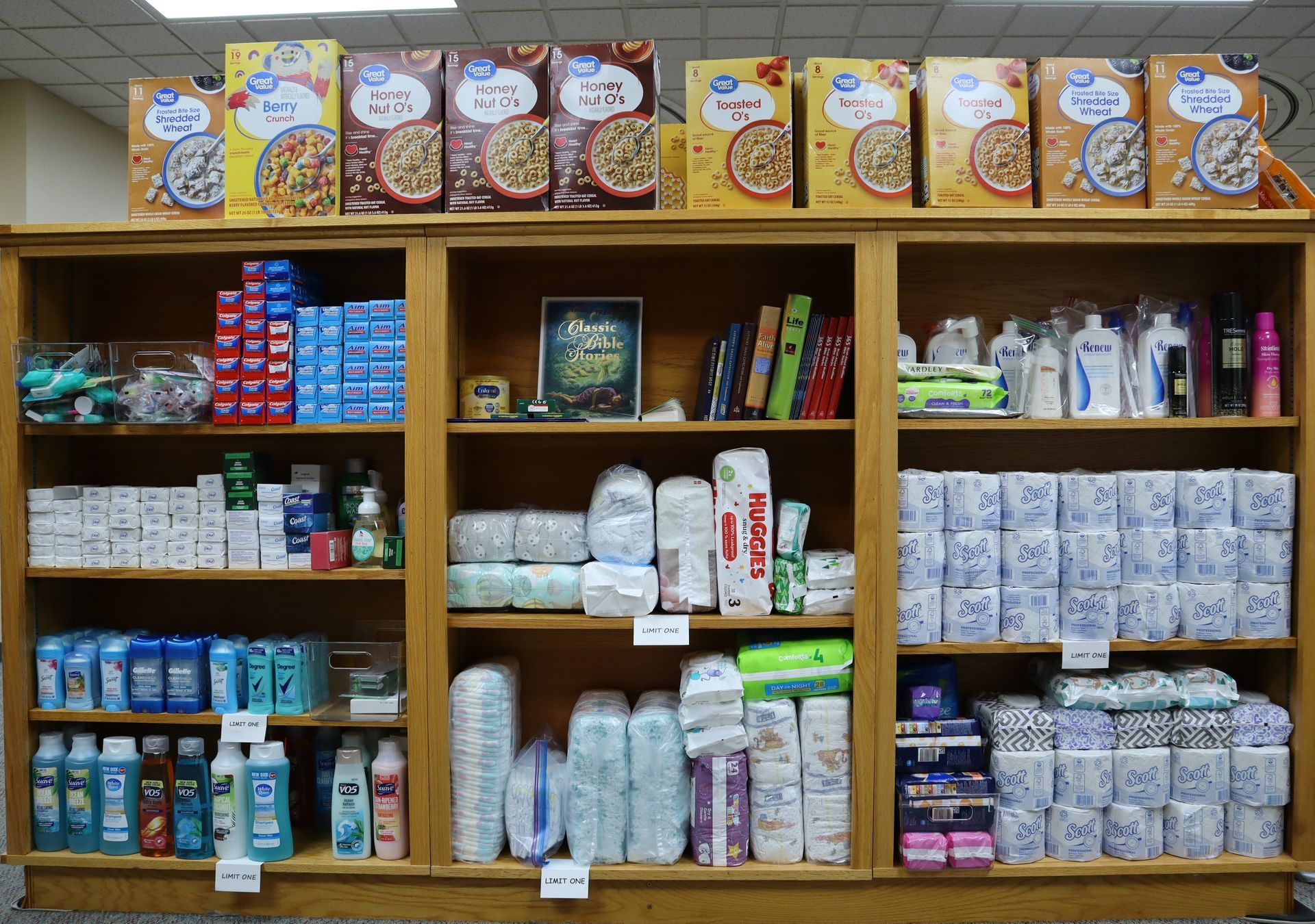 Shelves stocked with assorted packaged groceries and household goods in a small store.