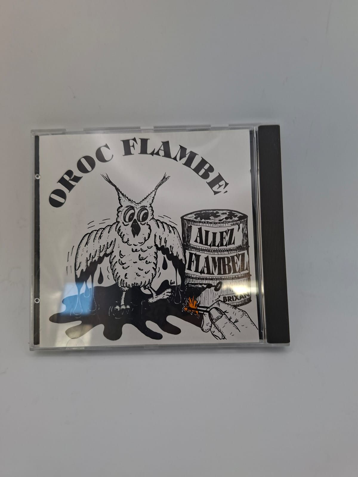 La custodia del CD presenta un'illustrazione in bianco e nero di un gufo in piedi accanto a una botte con l'etichetta