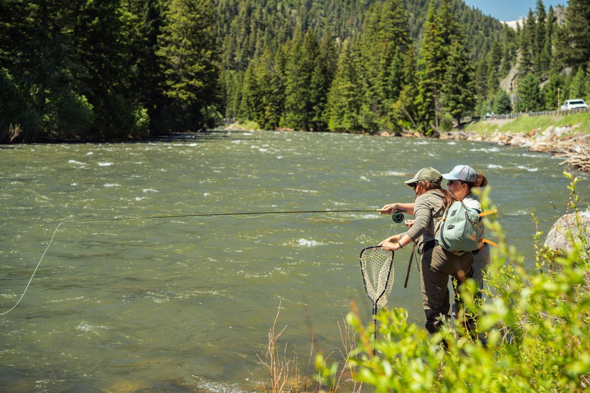 A couple of people are fishing in a river.