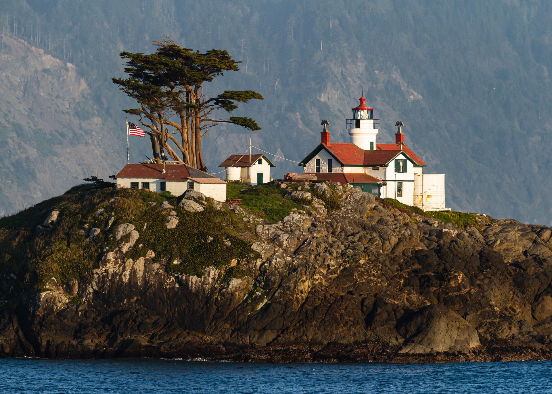 A small island with a lighthouse on top of it