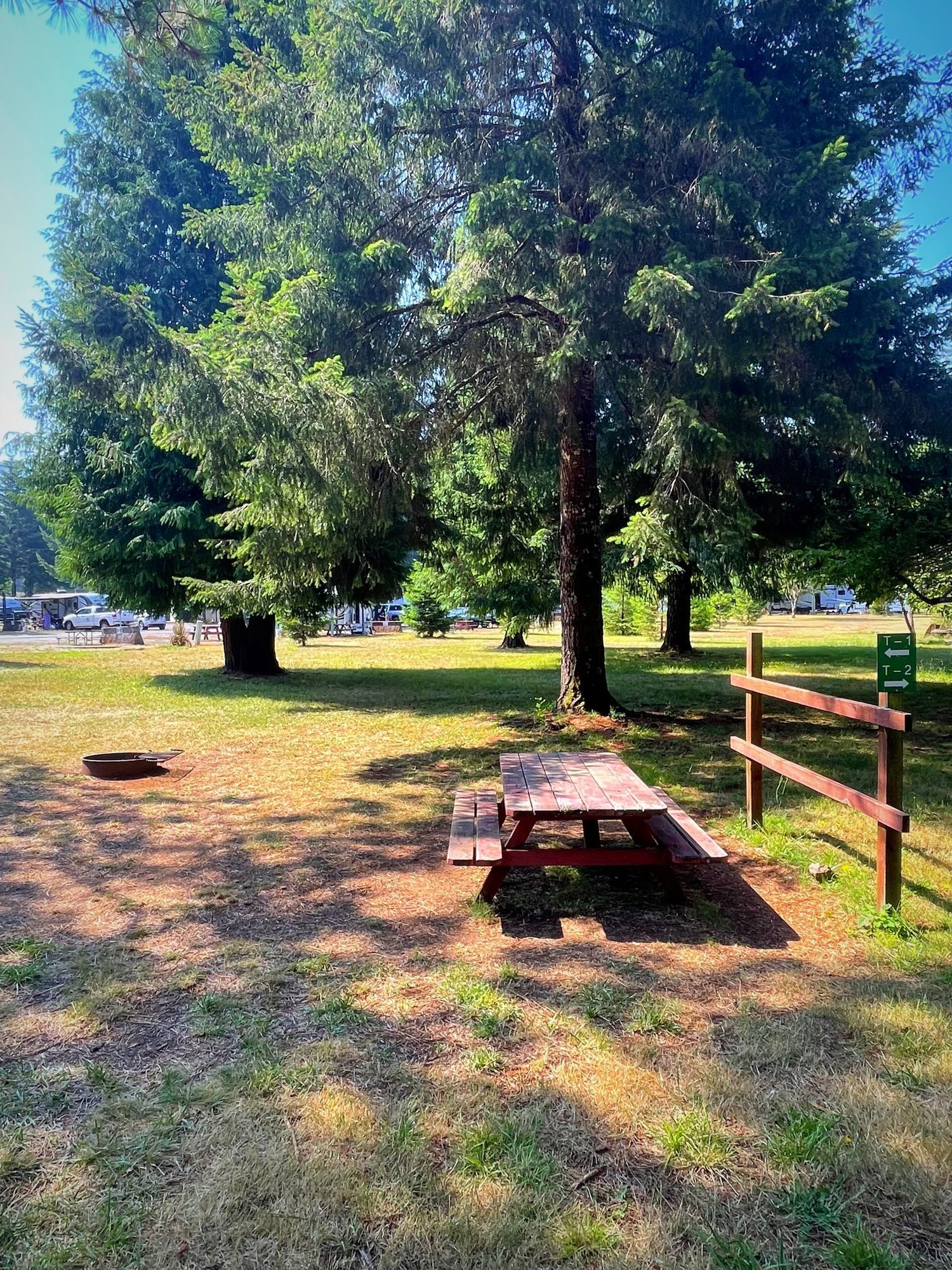 A picnic table is sitting in the middle of a grassy field in a park.